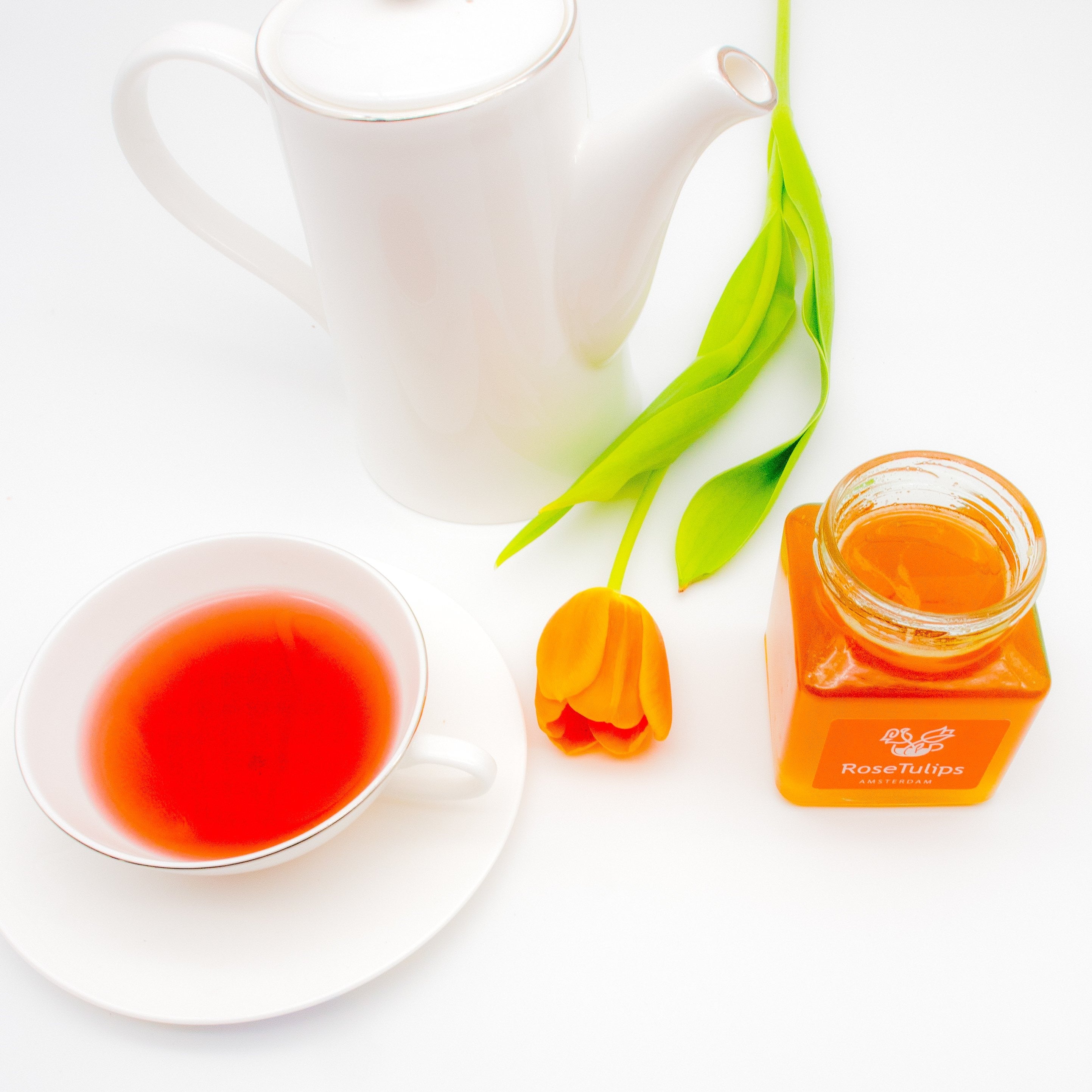 A cup of tea and a jar of linden honey.