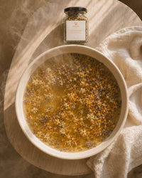 Soothe and Restore herbal infusion overhead — golden postpartum rinse and steam blend