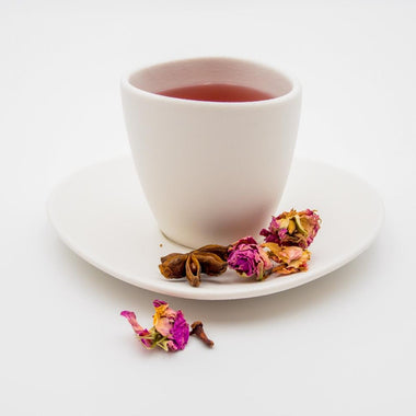Tee mit Hibiskus, Kakaobohnen, Orangenschale, Holunderbeere, Aroniabeere, Sternanis, Gojibeere, Rosa Damascena, Zimt und Steviablatt.